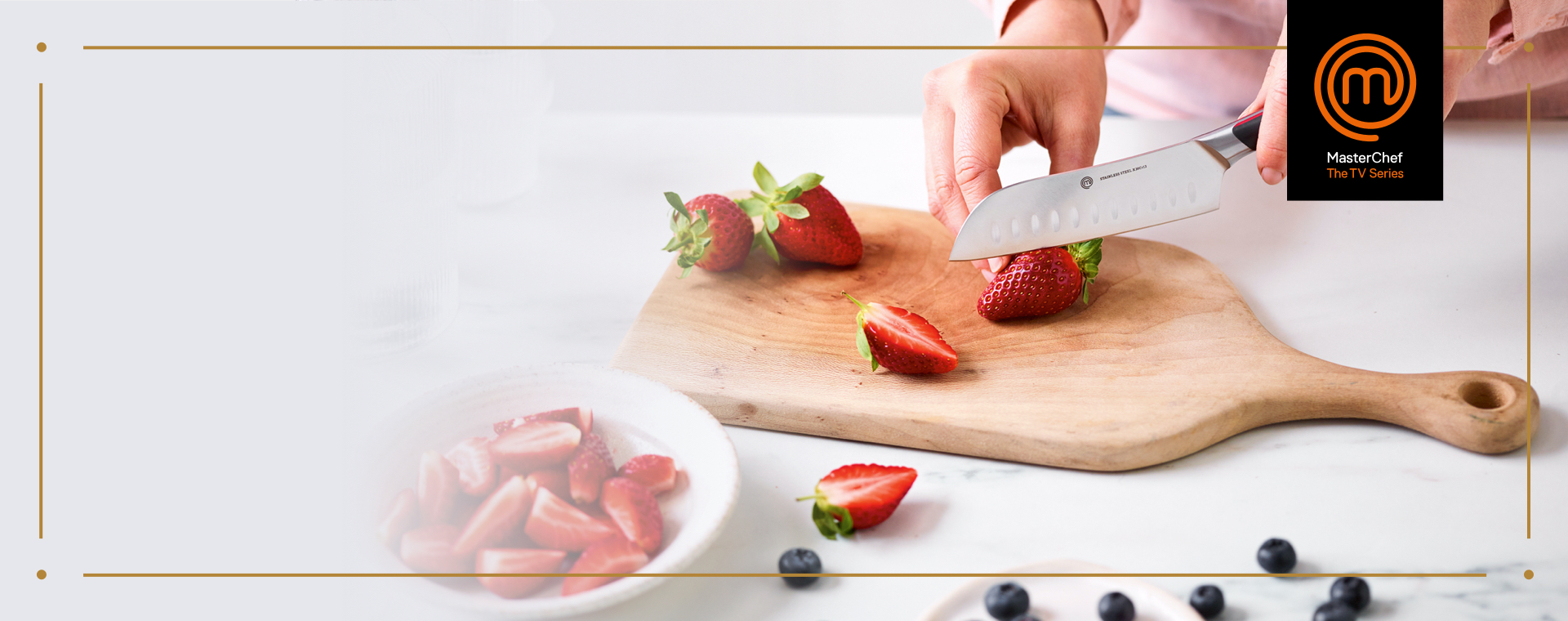 Close up of someone cutting Strawberries with a MasterChef Knife