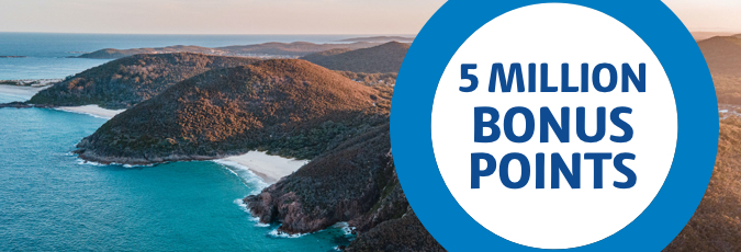 Collect a share of 5 million Flybuys bonus points 5 Million Bonus Points ring over an image of an aerial shot of a hilly beach