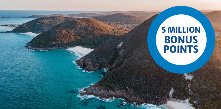 5 Million Bonus Points ring over an image of an aerial shot of a hilly beach