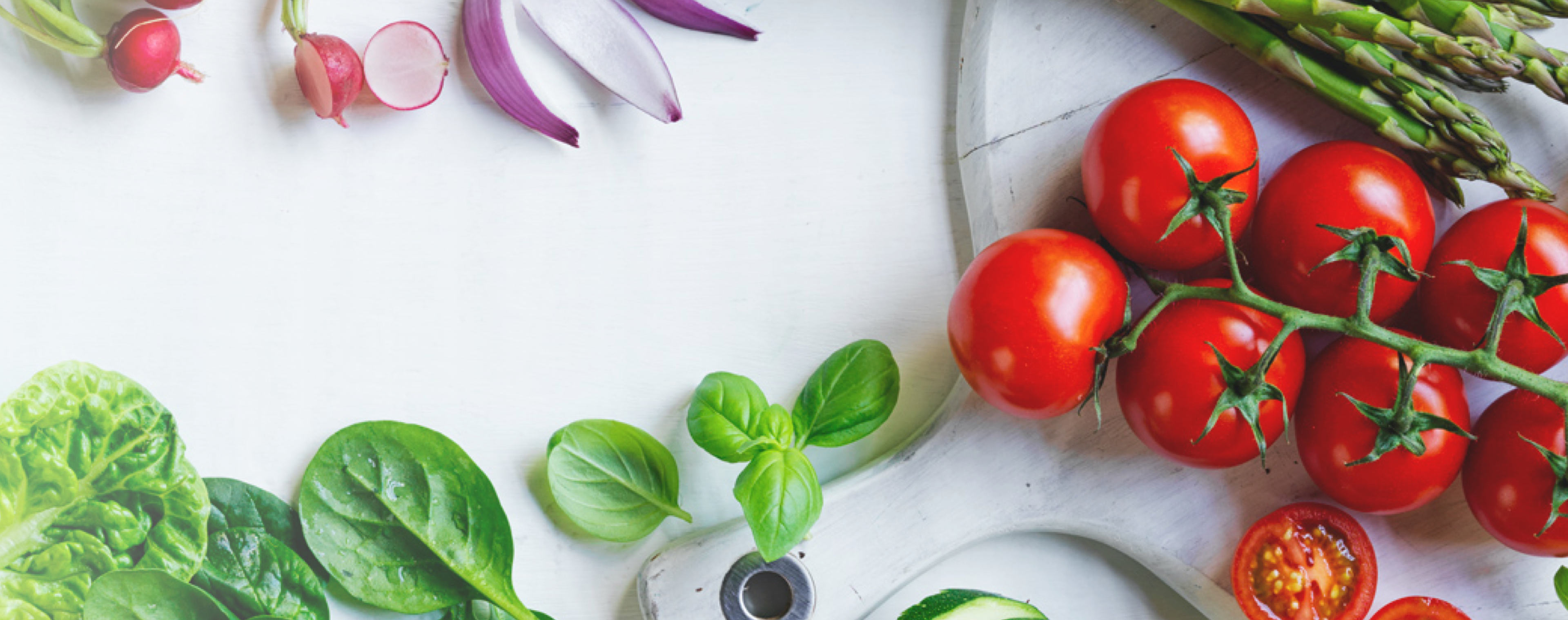 Camera looking down on tomatos and basil laid on a table