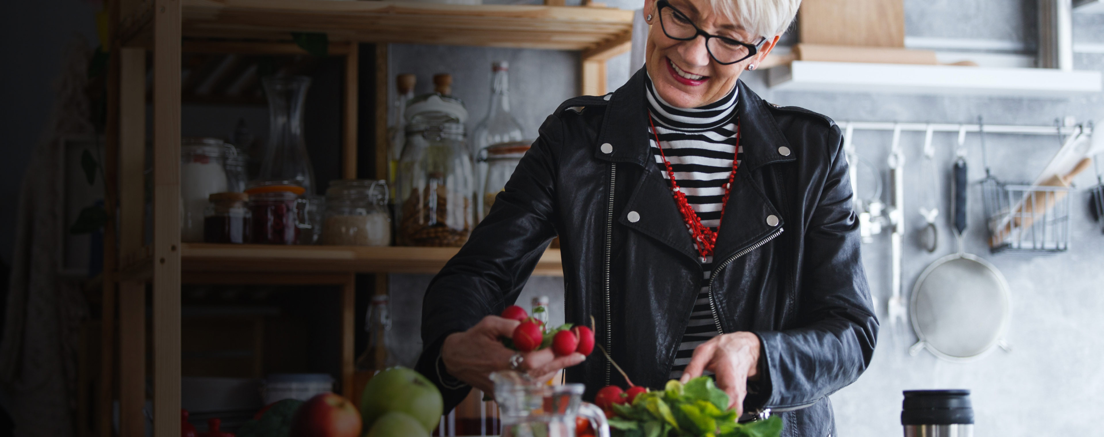 Lady in a kitchen looking at food on the bench