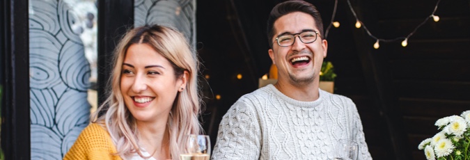 Enjoy additional benefits of the Citi Rewards Card Happy couple enjoy a laugh together surrounded by fairy lights