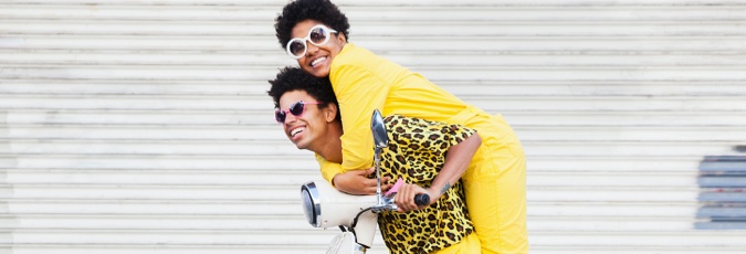 Collect both Flybuys points and Citi reward Points Young man in bright yellow and black shirt piggybacking young woman in bright yellow jumpsuit