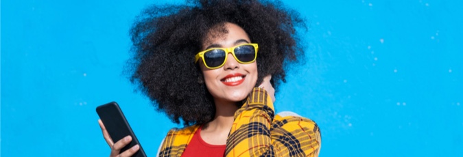 When will I get my Flybuys points? African American woman with sunglasses and a mobile phone against a light blue background