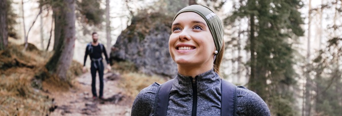 A match made in health Image of a young woman with a backpack on a hiking trail, smiling.