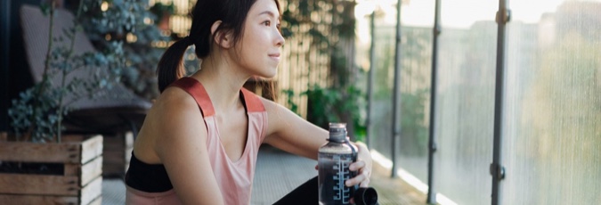 What are waiting periods? Image of a young Asian woman in athletic attire gazing out of a window.