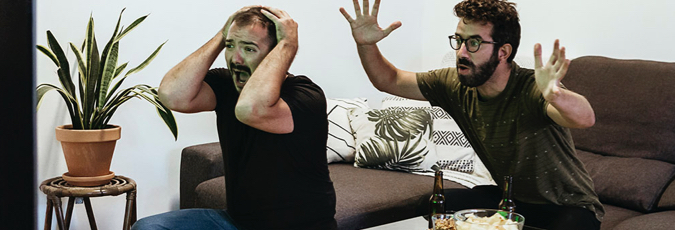 Optus Sport is included with all postpaid Optus SIM plans Two young men reacting to watching sport on the couch