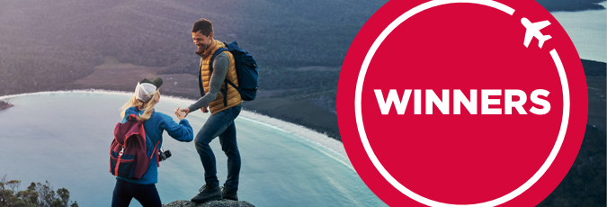 See our major prize winners Image of a woman and a man with backpacks at the top of peak overlooking the beach