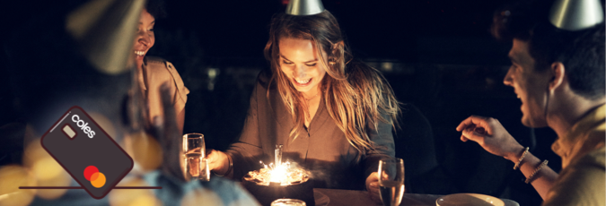 Make your everyday more rewarding Young woman surrounded by friends sitting in front of a birthday cake with candles and sparklers