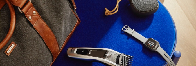Gift guide for him A range of products set against a blue velvet chair