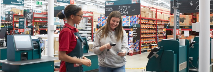 Collect points at Bunnings A smiling young woman having her Flybuys card scanned by a cheerful young Bunnings employee