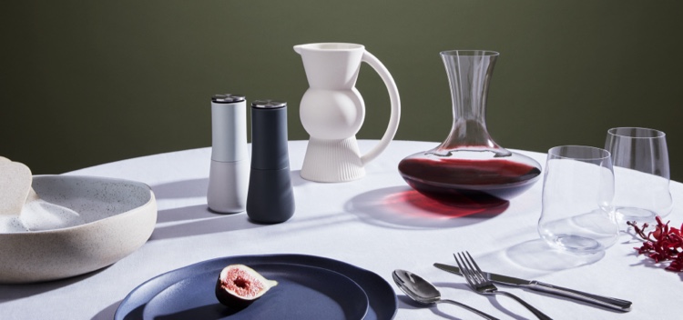Make your home a sanctuary. Beautiful table set with wine decanter, wine glasses, plates, cutlery, salad bowl, servers and water jug. 