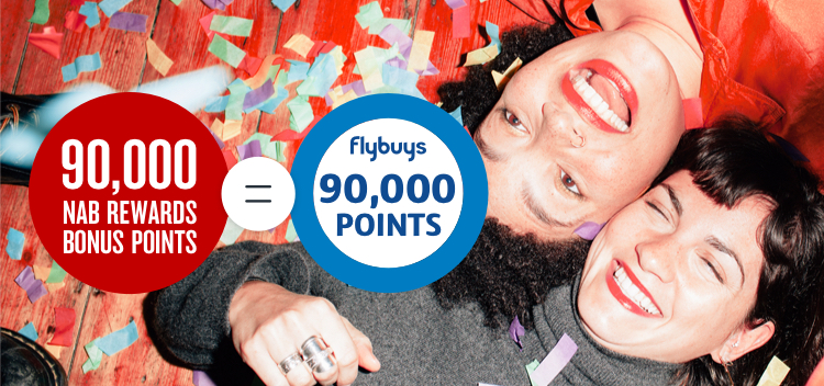 Two ladies laying on the floor being showered in confetti next to a 90,000 NAB points ring and 90,000 Flybuys points ring 