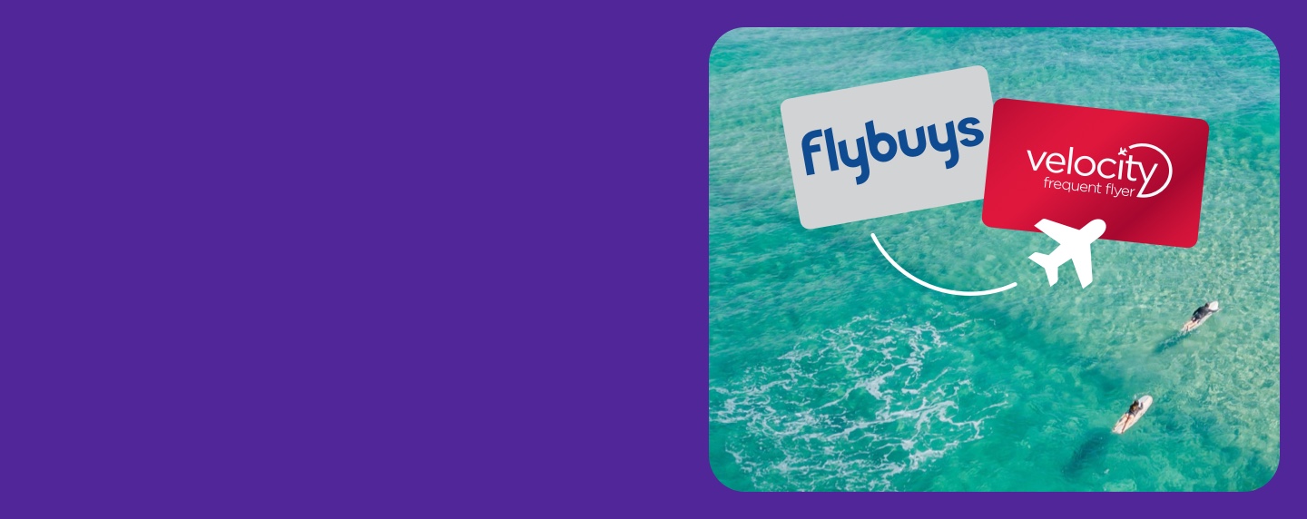 Flybuys card and Velocity Frequent Flyer Cards over layed on an areal view of the beach