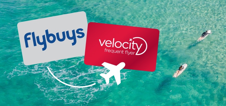 Flybuys card and Velocity Frequent Flyer Cards over layed on an areal view of the beach
