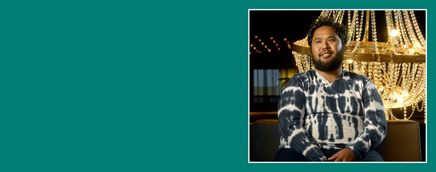 Flybuys' top 10 member Moris smiling next to chandelier