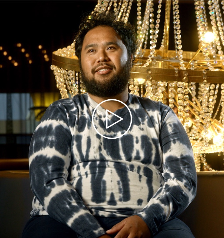 Flybuys' top 10 member Moris smiling next to chandelier