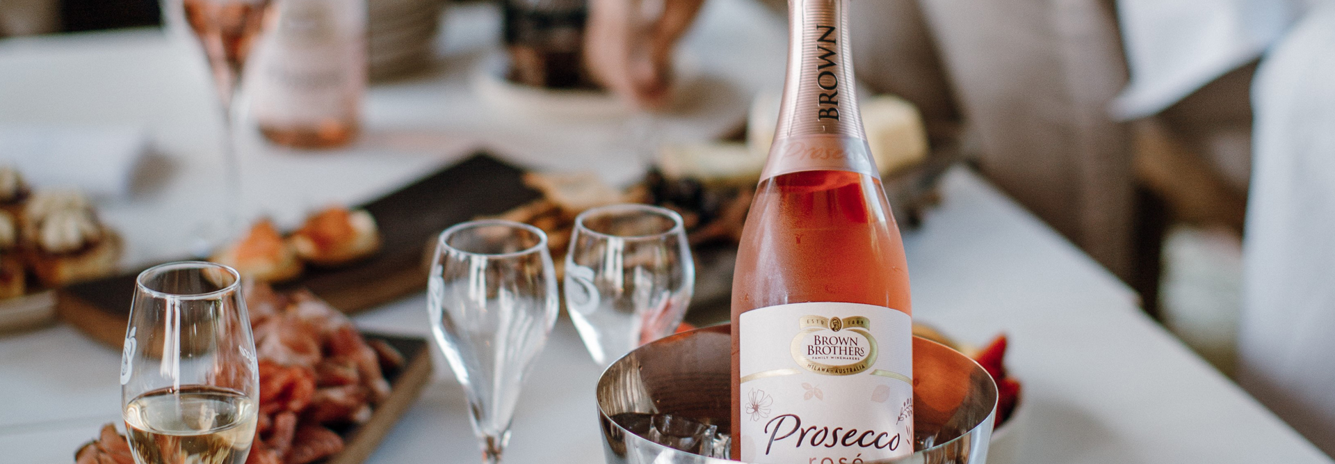 Chilled Brown Family Prosecco Rose next to food spread