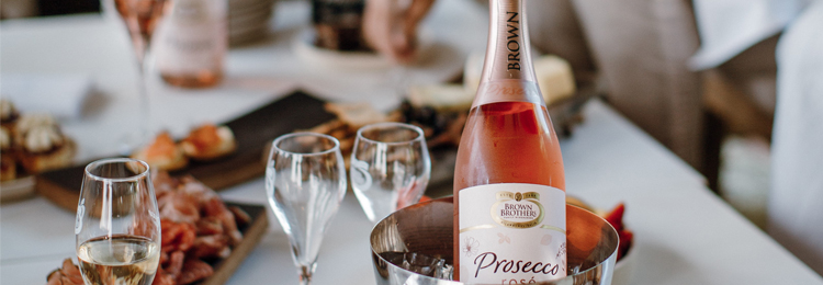 Chilled Brown Family Prosecco Rose next to food spread