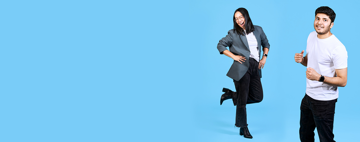 Team members dancing in front of a blue background