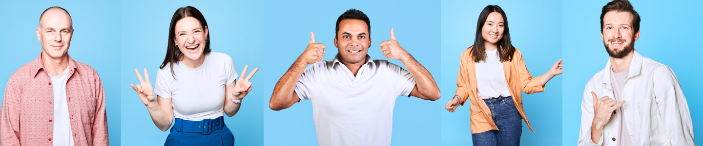 Excited employees standing in front of a blue background