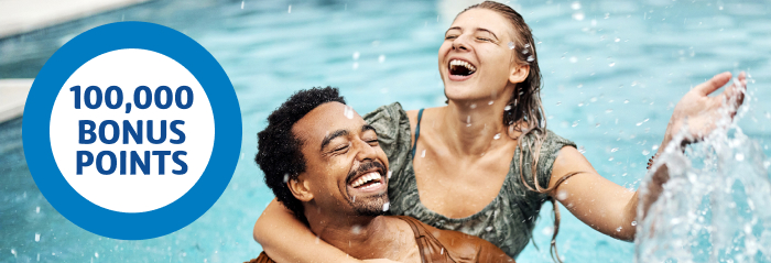 10,000 bonus points Young couple playing in the pool