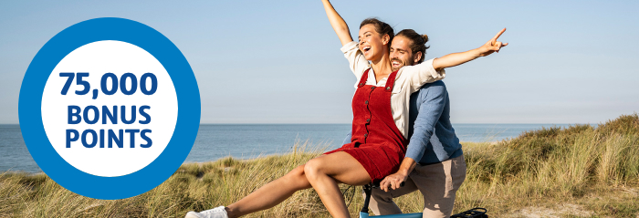 Happy couple cycling alongside coastline