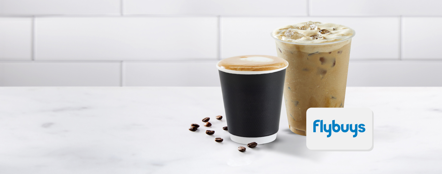Two cups of coffee on a white table with a Flybuys card.