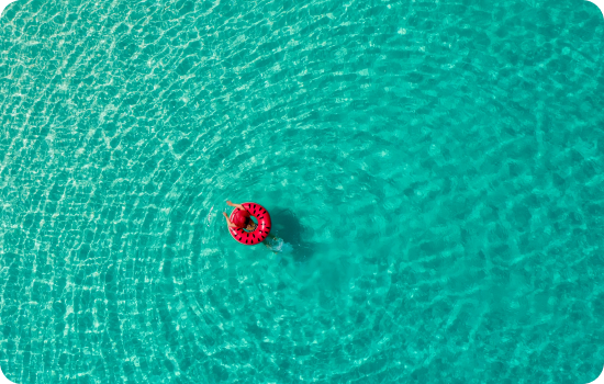 Person floating in inflatable donut in sea