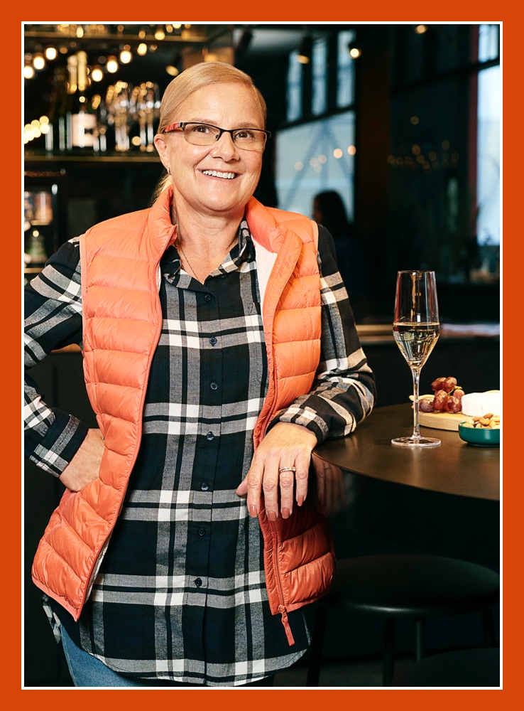 Flybuys' top10 member Angela sitting next to a glass of wine in a restaurant